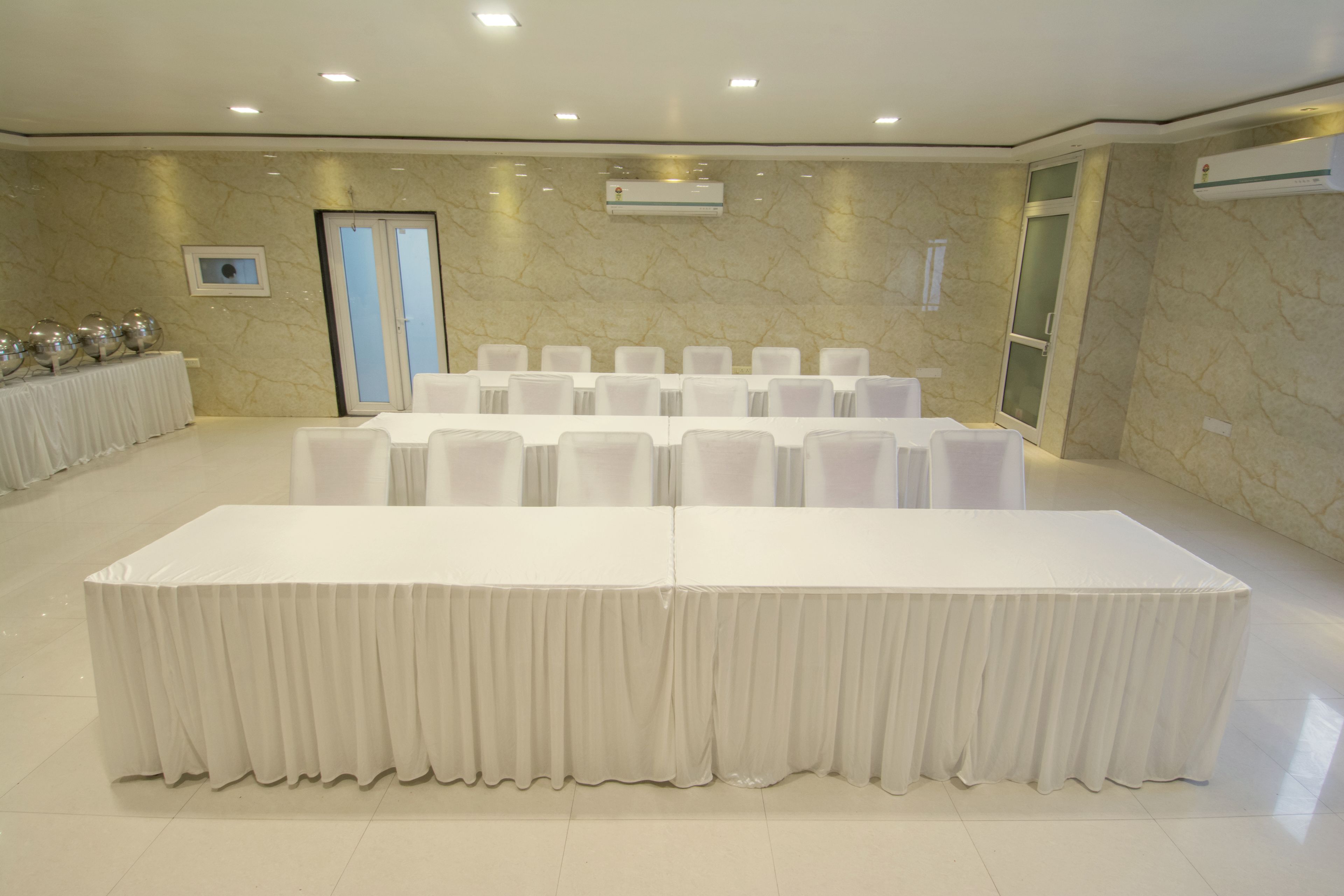 A conference room with a long table, chairs, and an air conditioning unit on the wall.