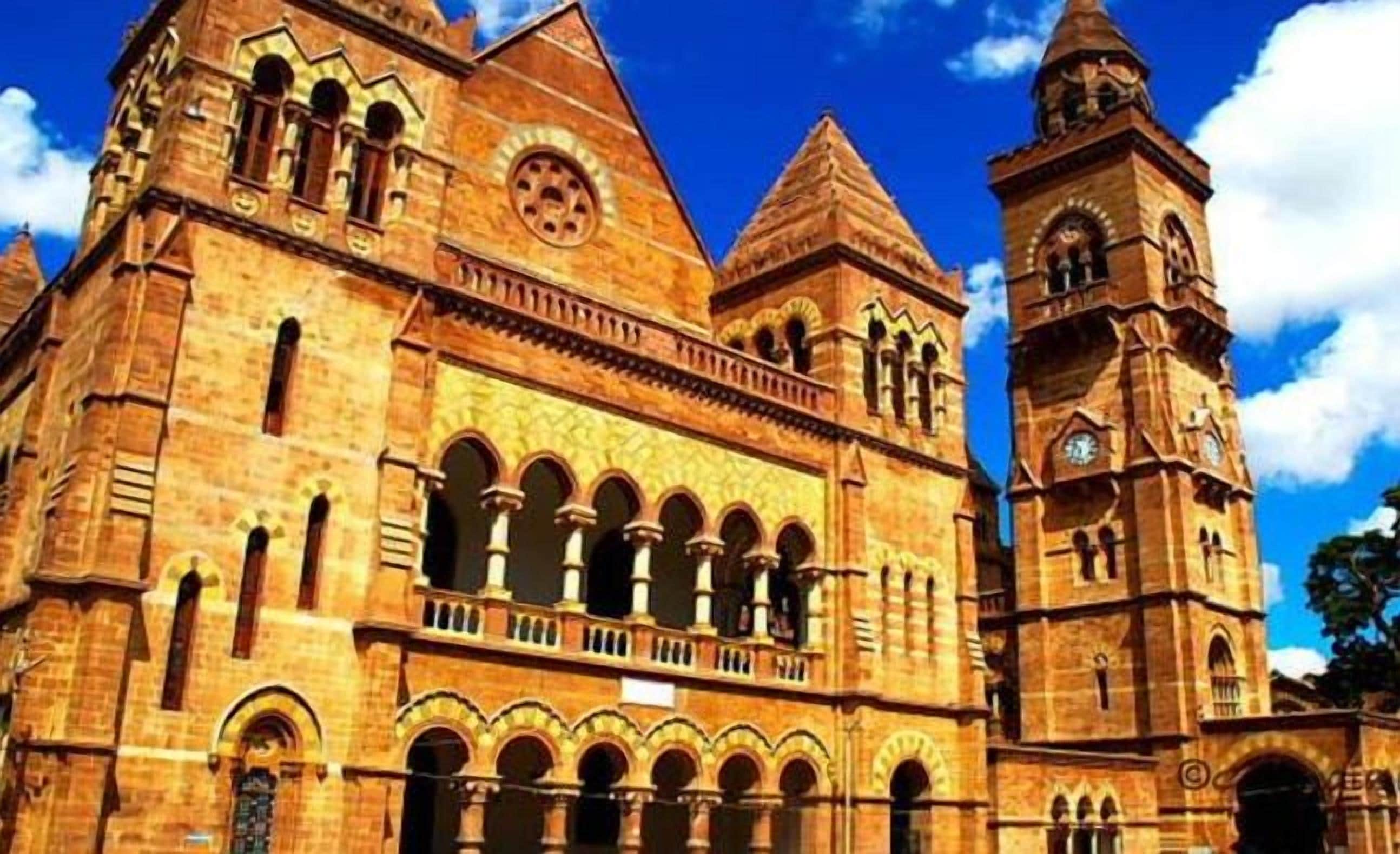 Un grand bâtiment historique doté de nombreuses arcades et d’un imposant clocher.