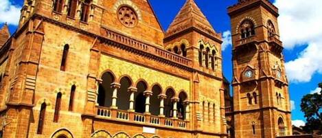 Un grand bâtiment historique doté de nombreuses arcades et d’un imposant clocher.