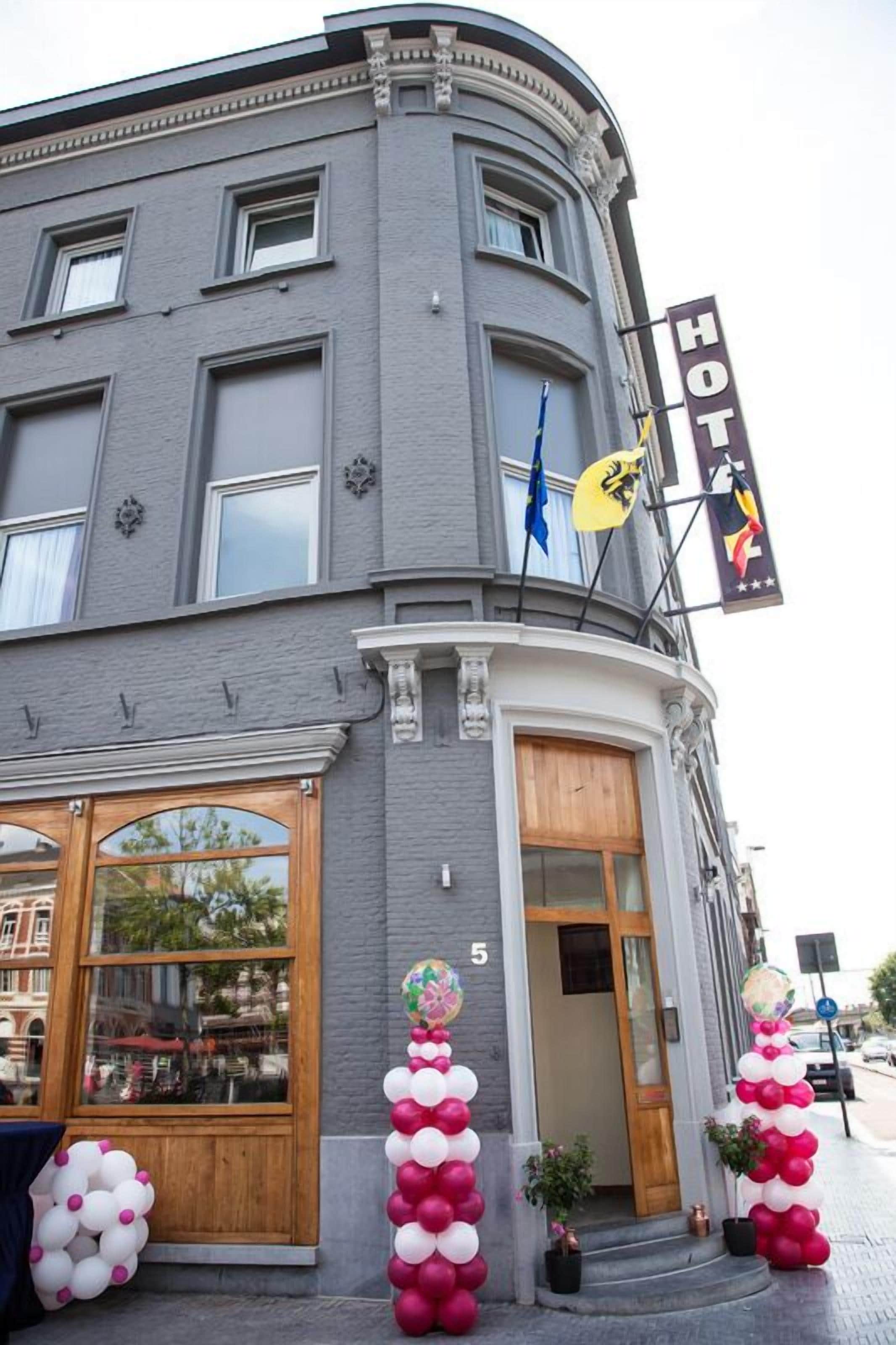 A corner building with a 'HOTEL' sign, large windows, and a wooden door.