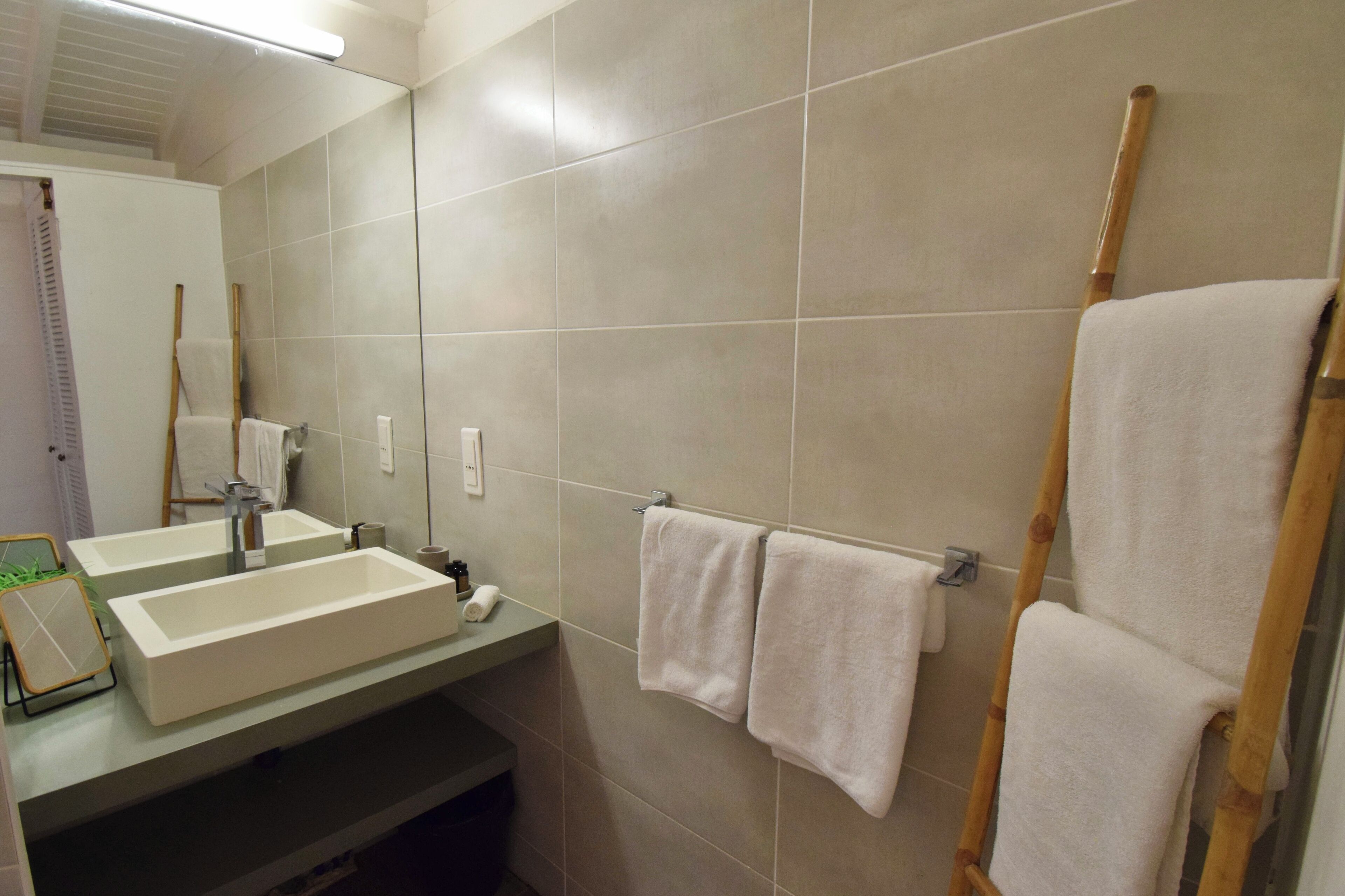 Une salle de bain avec deux lavabos, un miroir et un porte-serviettes avec deux serviettes.