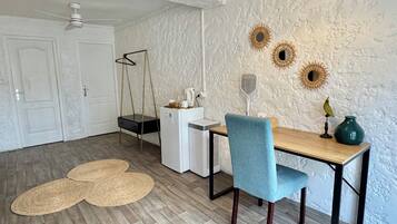 Un espacio de comedor compacto con una mesa de madera, una silla azul y un refrigerador blanco.