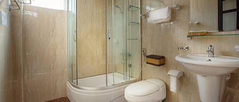A modern bathroom with a glass-enclosed shower, a white toilet, and a pedestal sink.