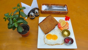 A breakfast plate with toast, eggs, fruit, and condiments on a table. - Thamel Grand Hotel (Kathmandu)