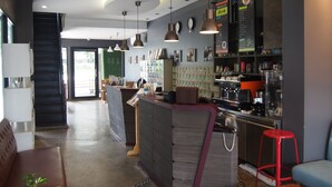 Un área de bar moderna con mostrador, asientos y una máquina de café.