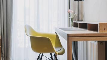 Una habitación moderna con una silla amarilla, una mesa de madera, un radiador y una lámpara.