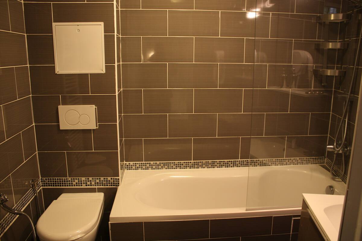 Un baño con bañera, inodoro y zona de ducha.