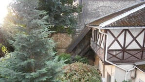 A traditional building with a timber-framed structure, a brick wall, and a staircase leading to an upper level. - Hôtel Beauséjour (Rouen)