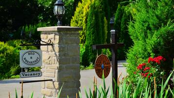 A stone pillar with a sign indicating a bed and breakfast, a vintage lantern, and a compass sign.