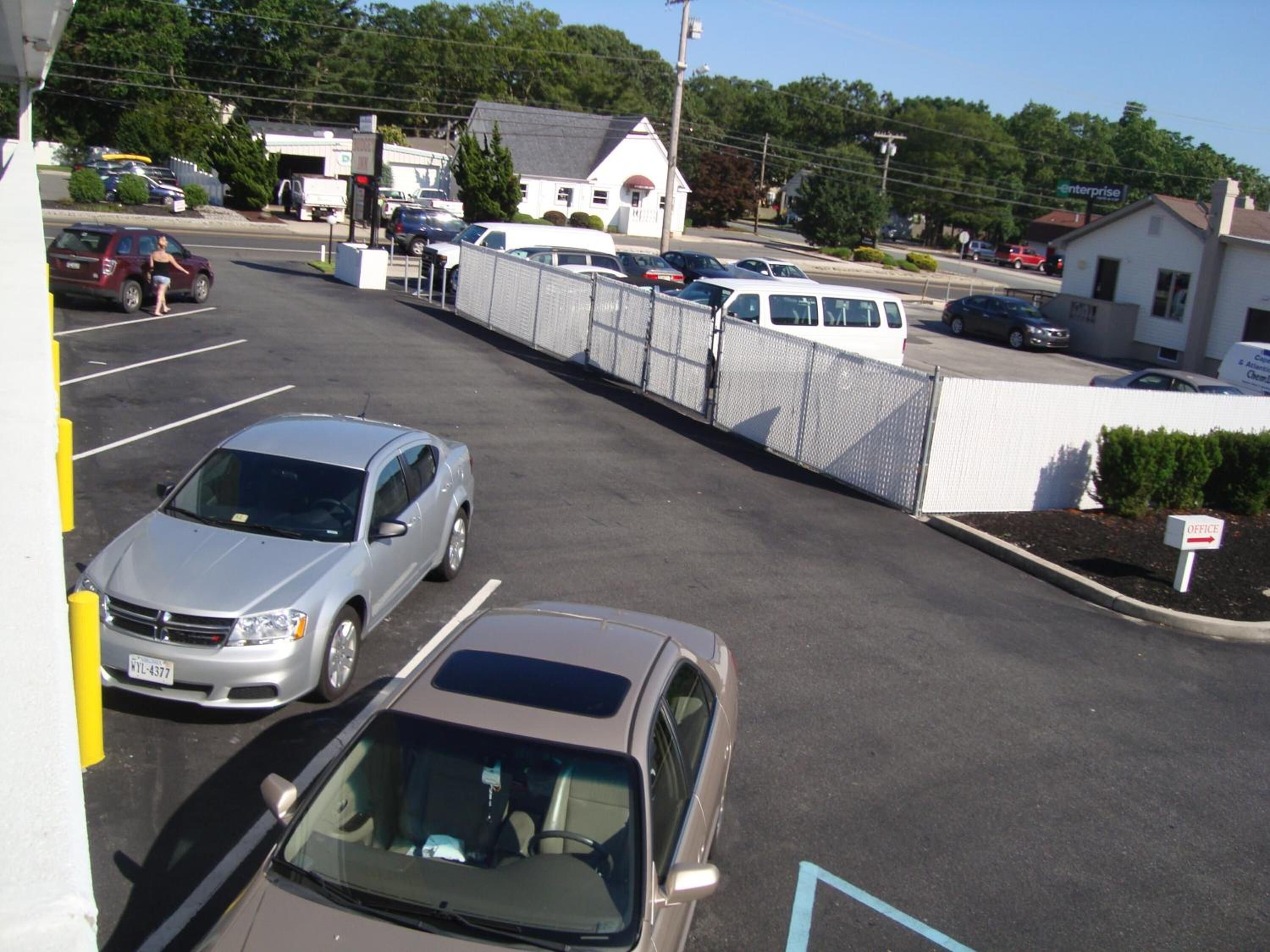 A parking lot with multiple cars, a fenced area, and a building labeled "Enterprise".