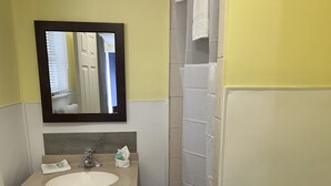 A bathroom with a sink, mirror, and towel rack. - Budget Inn Motel Suites (Somers Point)