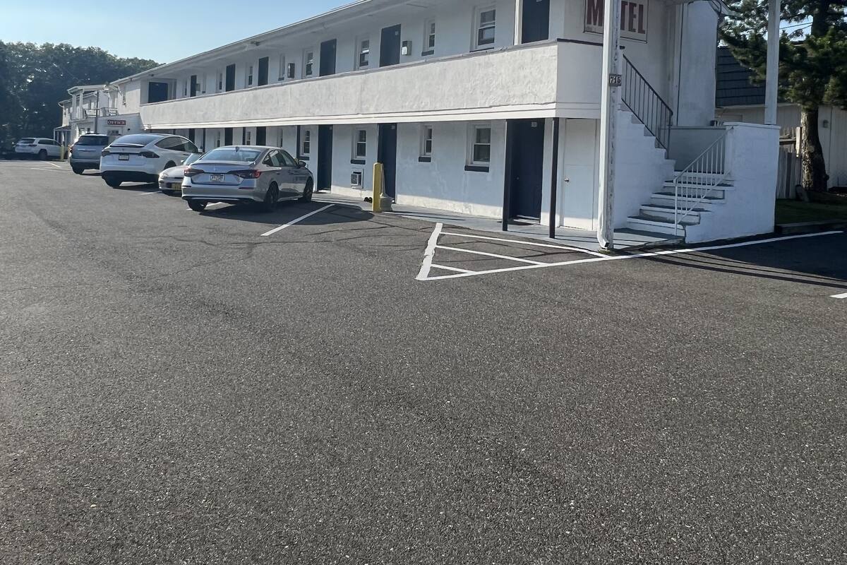 A two-story motel with a covered front porch and a staircase leading to the entrance.