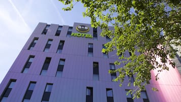 Un hotel moderno con fachada morada y el logotipo de B&B.