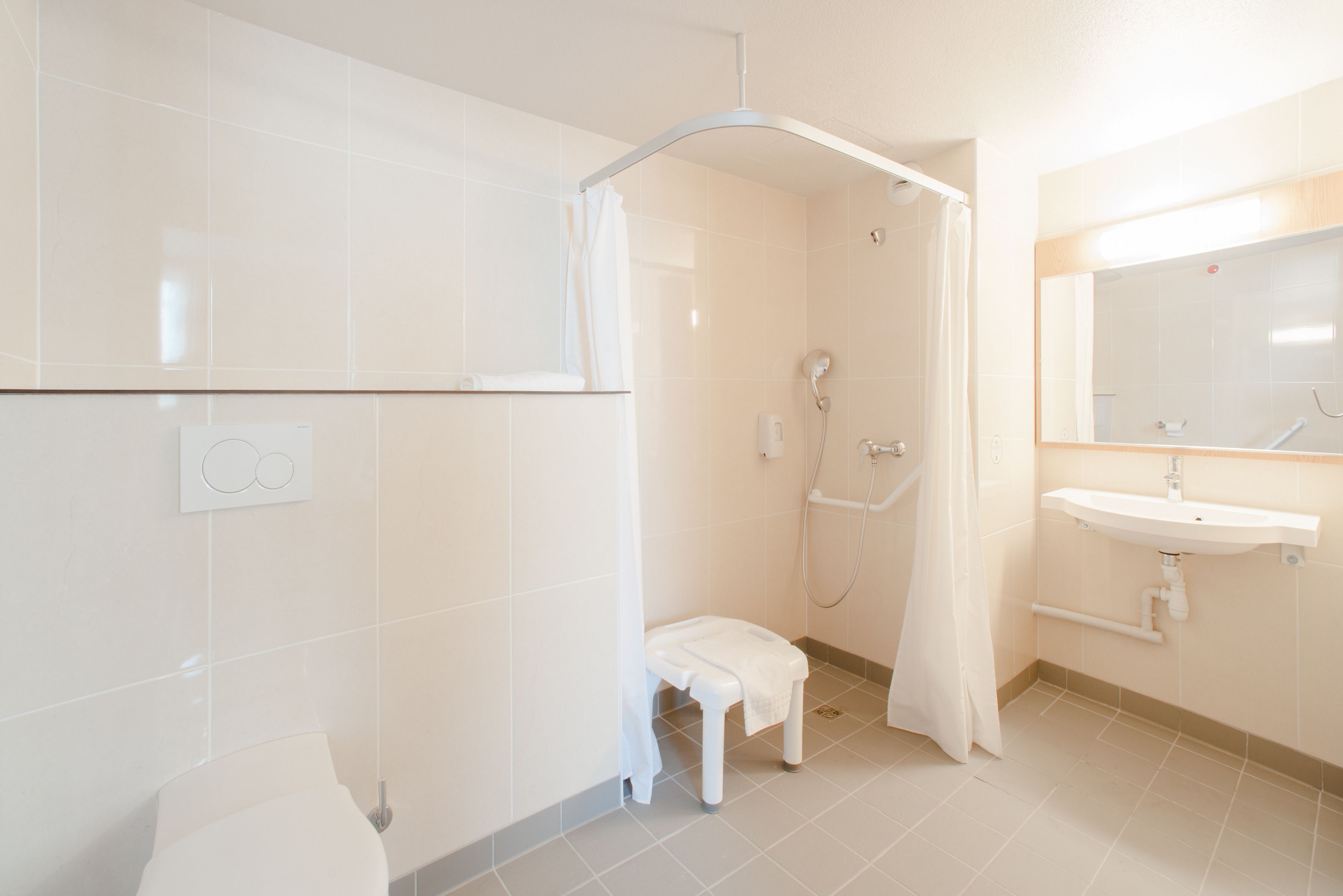 A modern bathroom with a shower, toilet, and sink.