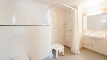 A modern bathroom with a shower, toilet, and sink.
