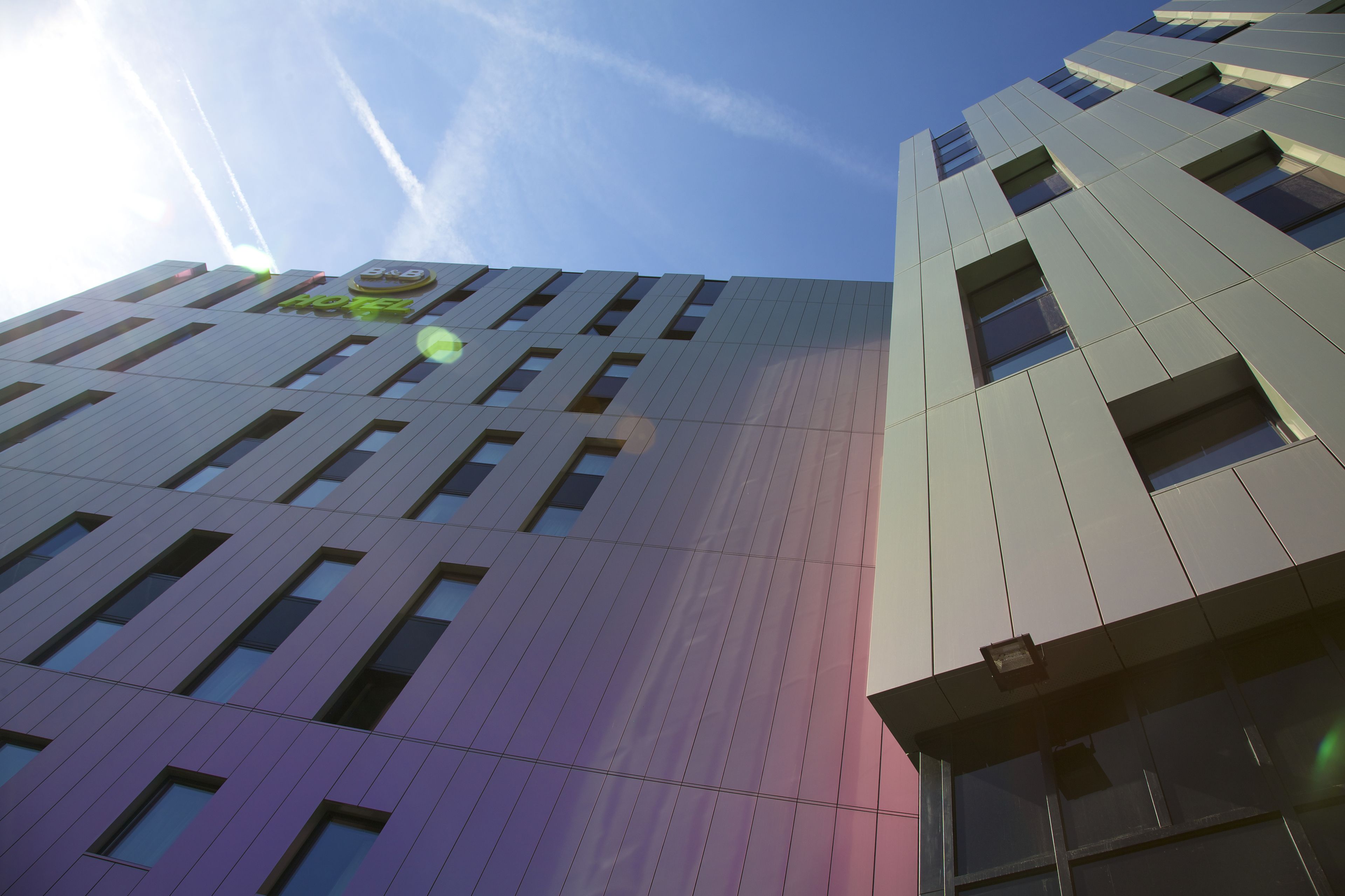 Un bâtiment moderne avec une enseigne bien visible indiquant qu’il s’agit d’un hôtel.