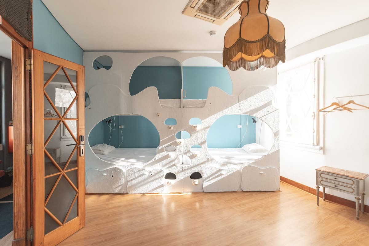 A room with a unique geometric wall design, a wooden door, and a small wooden side table.