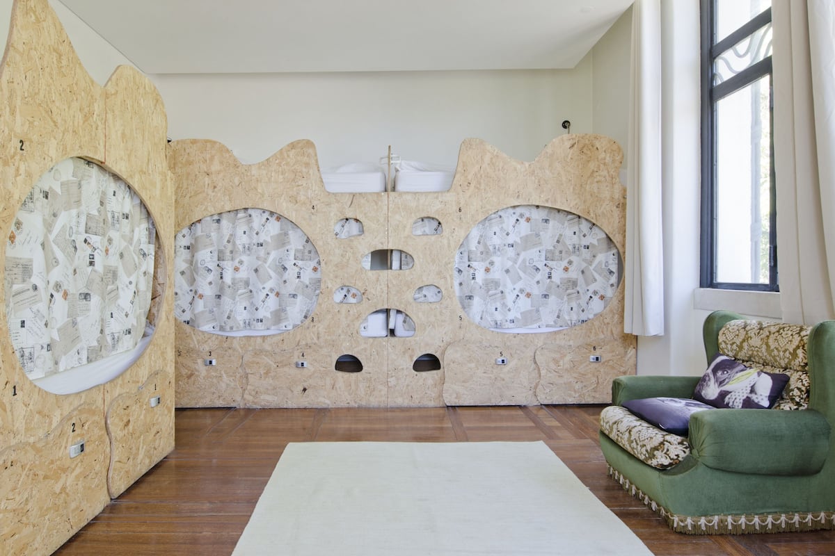 A room with a unique wall design featuring numbered sections, a green armchair, and a large window.