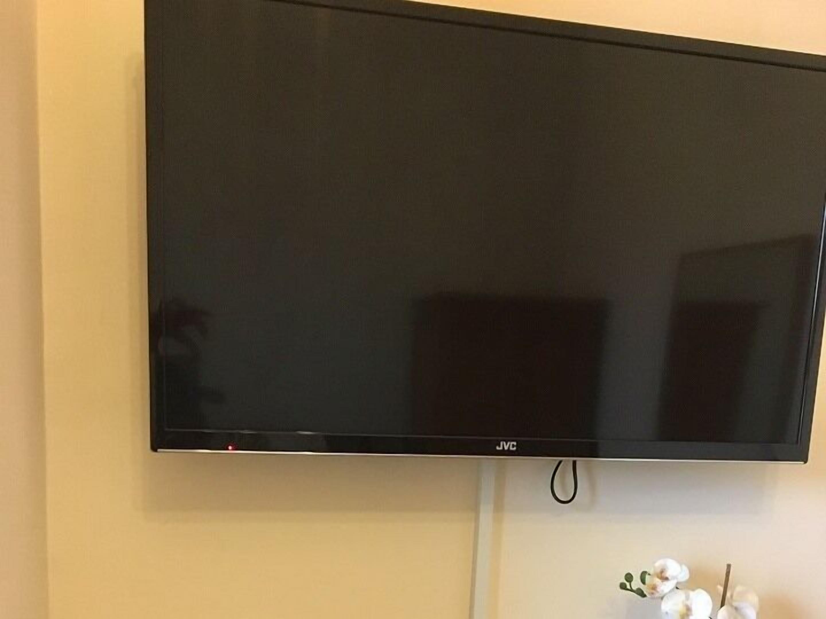 Een flatscreen televisie aan een muur bevestigd.