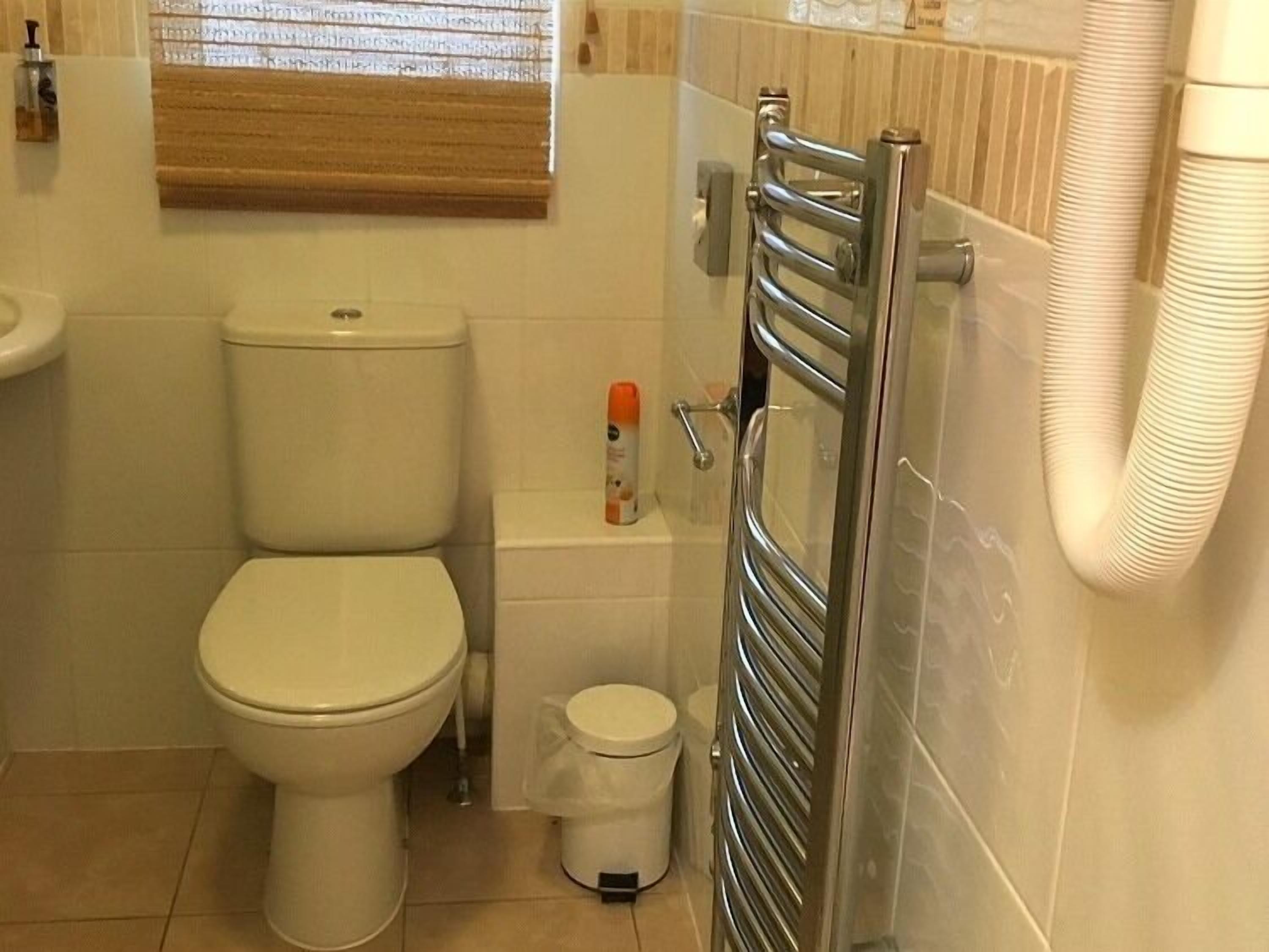 Un baño con inodoro, bidé y perchero para toallas.