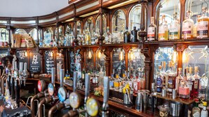 A bar with multiple taps and shelves of liquor bottles. - PubLove The White Ferry, Victoria - Hostel (London)