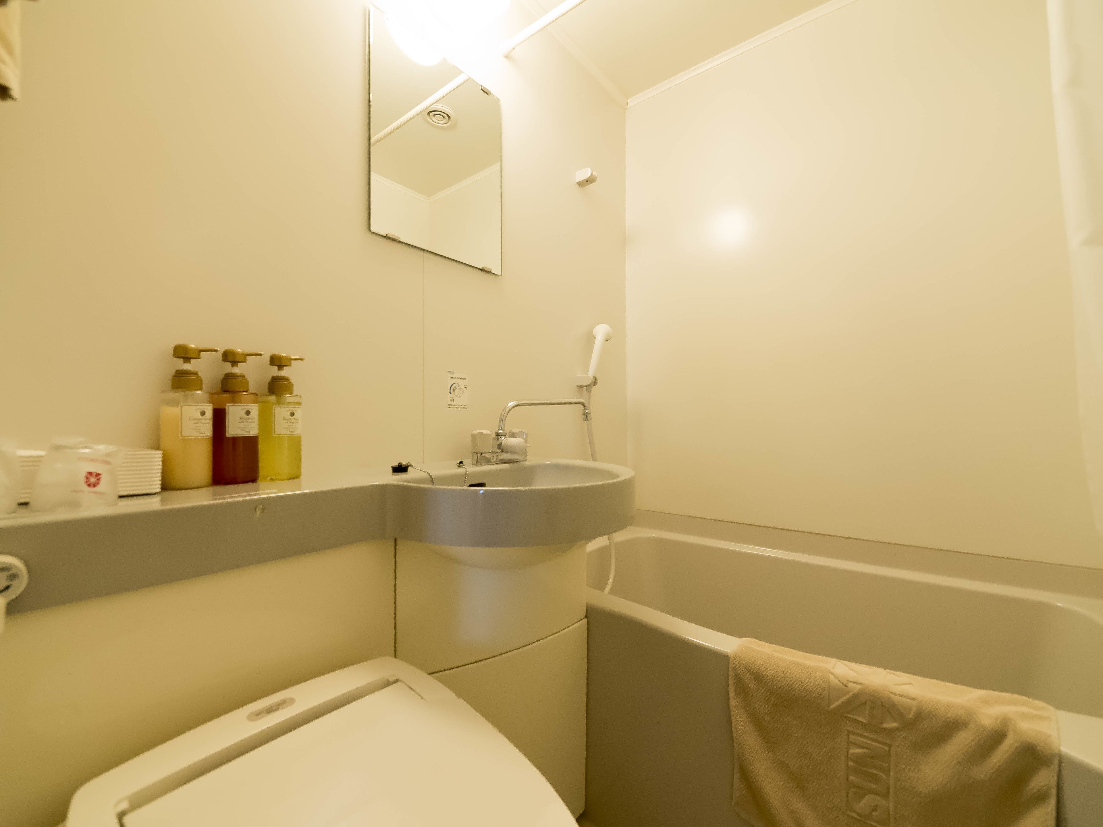 A bathroom with a sink, mirror, and toiletries.