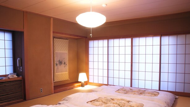 A traditional Japanese-style room with tatami flooring, shoji screens, and a futon bed. - Hotel Matsunoka Ichinoseki (Ichinoseki)