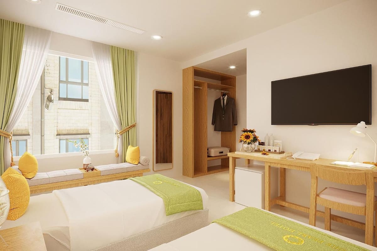 A hotel room with a bed, a desk, a TV, and a wardrobe.
