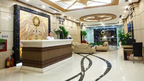 A hotel lobby with a reception desk, seating area, and a large wall mural. - The Pearl Hotel (Hanoi)
