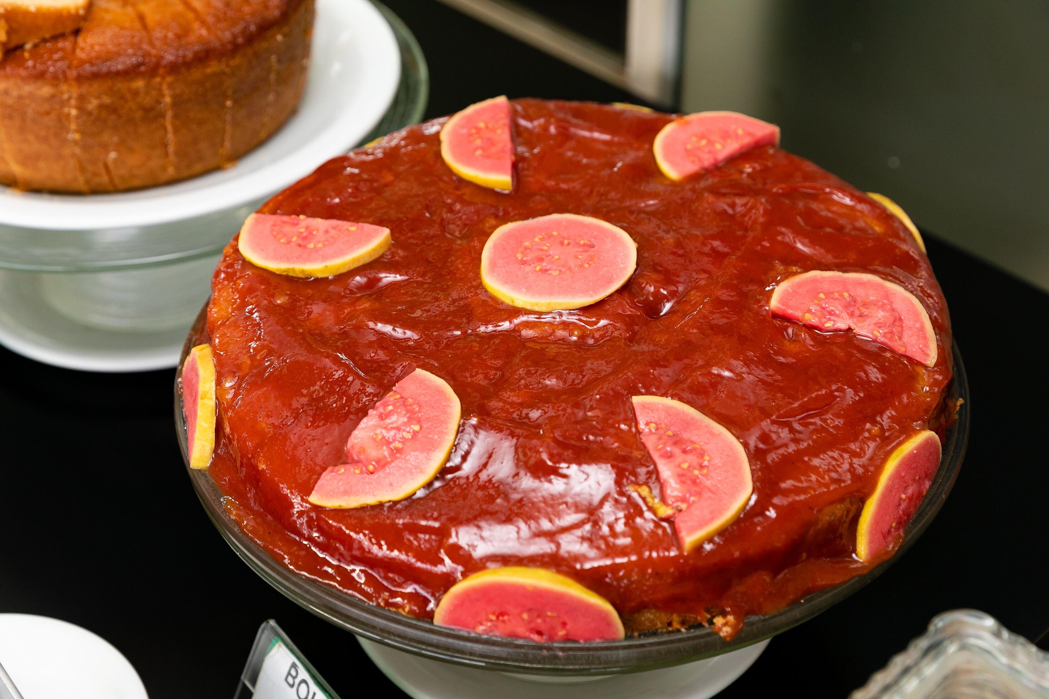 A dessert with a glossy red topping and slices of fruit on top.