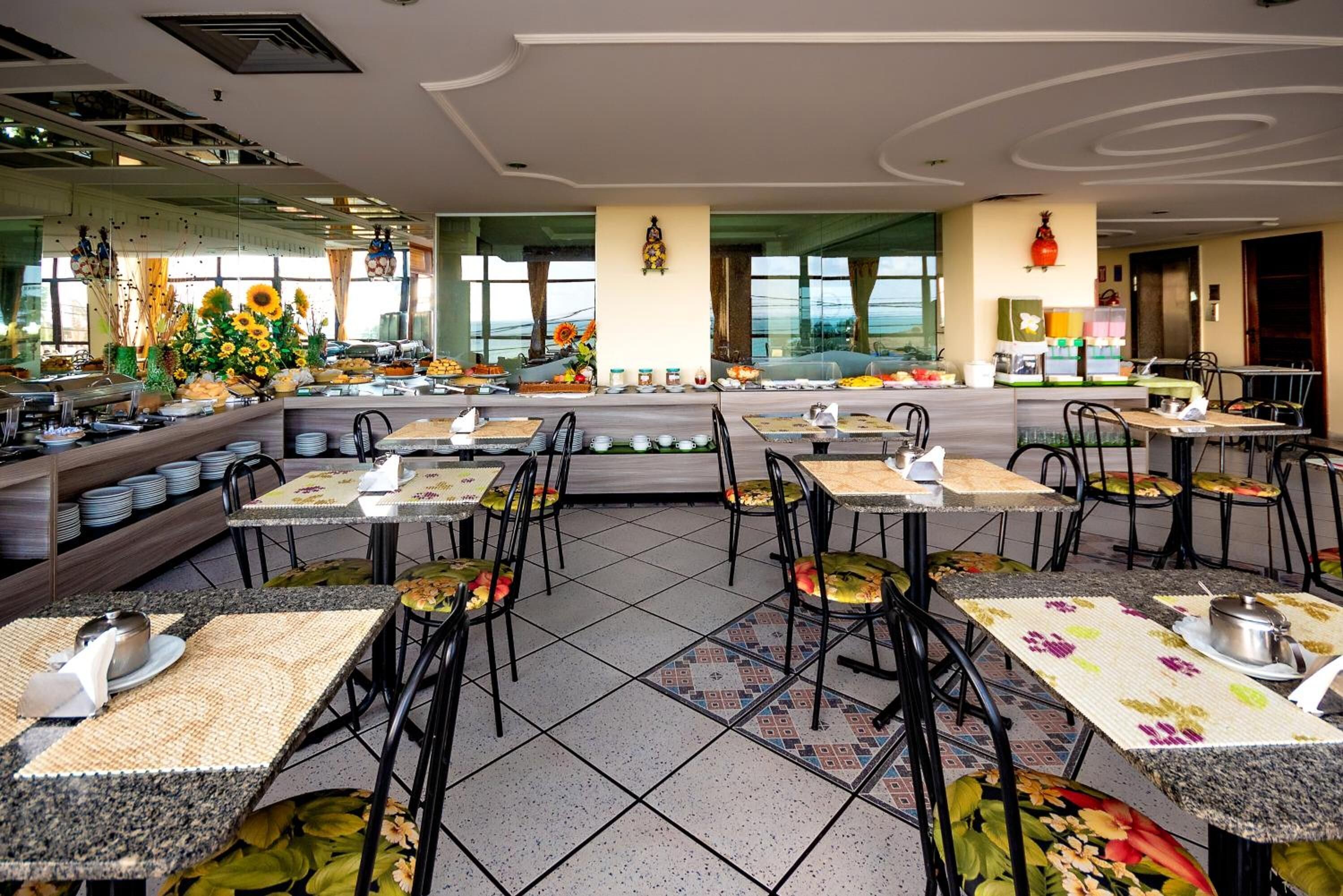 Un restaurant proposant un buffet, avec plusieurs tables et chaises pour les clients.