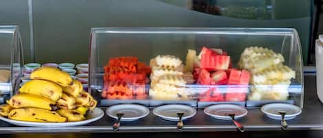 Una vitrina con diversas frutas y un plato de plátanos.