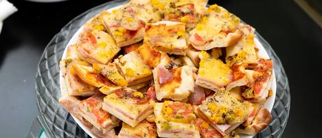 Una fuente de vidrio con varias porciones de pizza, algunas con vegetales y queso.