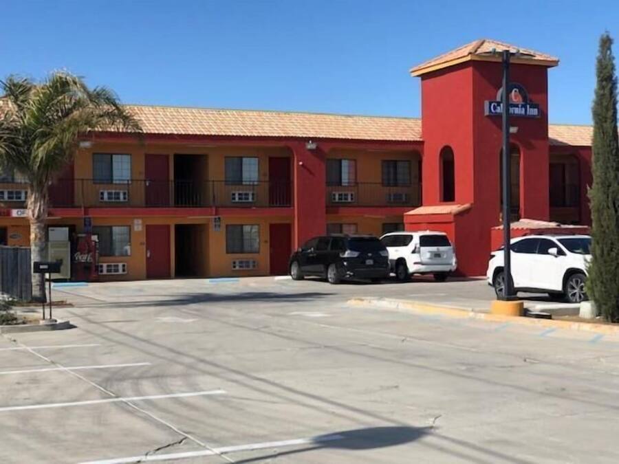 A multi-story hotel with a red facade and a prominent California Inn sign.