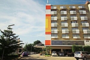 A multi-story hotel with a modern design, featuring a prominent vertical color strip on the facade.