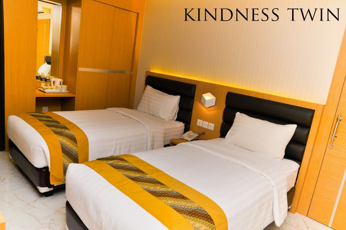 A hotel room with two beds, a bedside table with a phone, and a mirror.