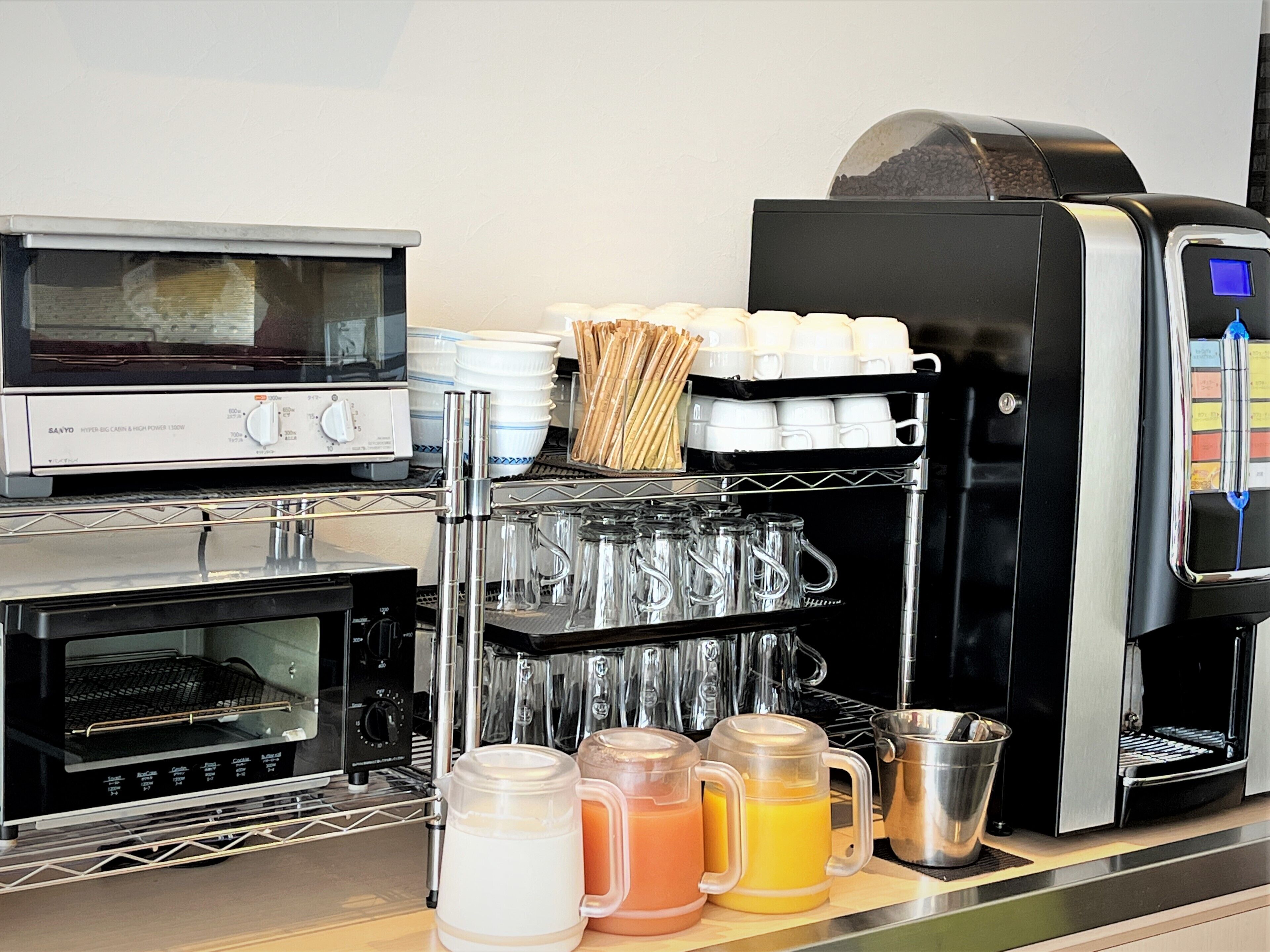 A commercial kitchen with a coffee machine, a toaster, and a coffee urn.
