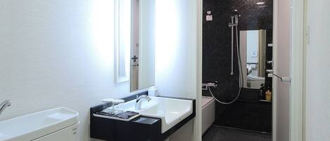 A modern bathroom with a toilet, sink, and shower.