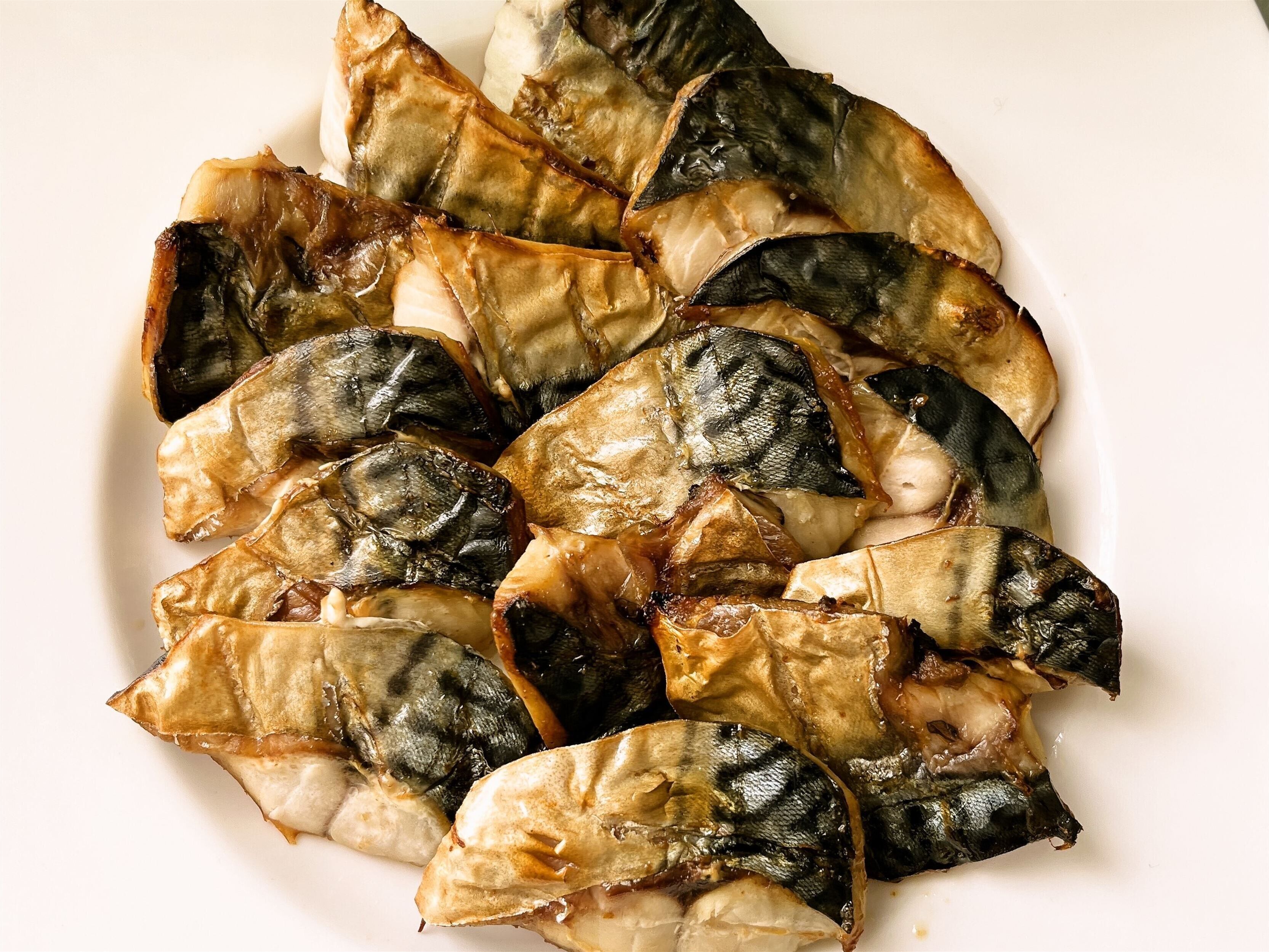 Een bord gegrilde vis met een goudbruine korst.