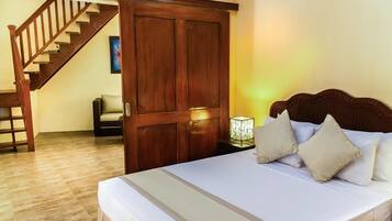 Un dormitorio con una cama de madera, una mesita de noche, una lámpara, una silla y una escalera.