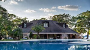 A modern house with a swimming pool, surrounded by tropical vegetation. - Matabungkay Beach Hotel (Lian)