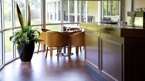 Una cocina moderna con comedor, ventanas amplias y una planta en maceta.