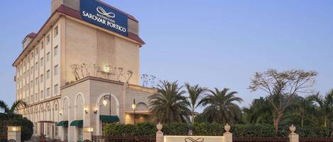 A hotel with a prominent sign reading "NIDHIVAN SAROVAR PORTICO".