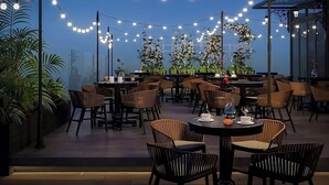 An outdoor dining area with string lights, round tables, and chairs. - Hotel Sapa Square, Affiliated by Meliá (Sa Pa)