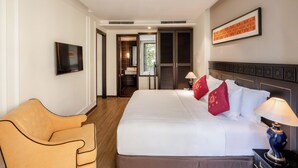 A hotel room with a large bed, a chair, a TV, and a door leading to a bathroom. - Hotel Sapa Square, Affiliated by Meliá (Sa Pa)