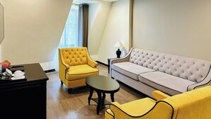 A modern living room with a yellow armchair, a grey sofa, and a small round table. - Hotel Sapa Square, Affiliated by Meliá (Sa Pa)