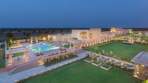 Un complexe hôtelier moderne doté d’une piscine, d’espaces extérieurs aménagés et de jardins bien entretenus.