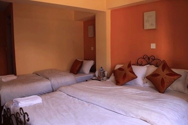 A hotel room with two beds, beige walls, and a simple decor. - Cosy Hotel (Bhaktapur)