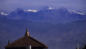 A mountain range with snow-capped peaks and a traditional building with a pointed roof in the foreground. - Cosy Hotel (Bhaktapur)