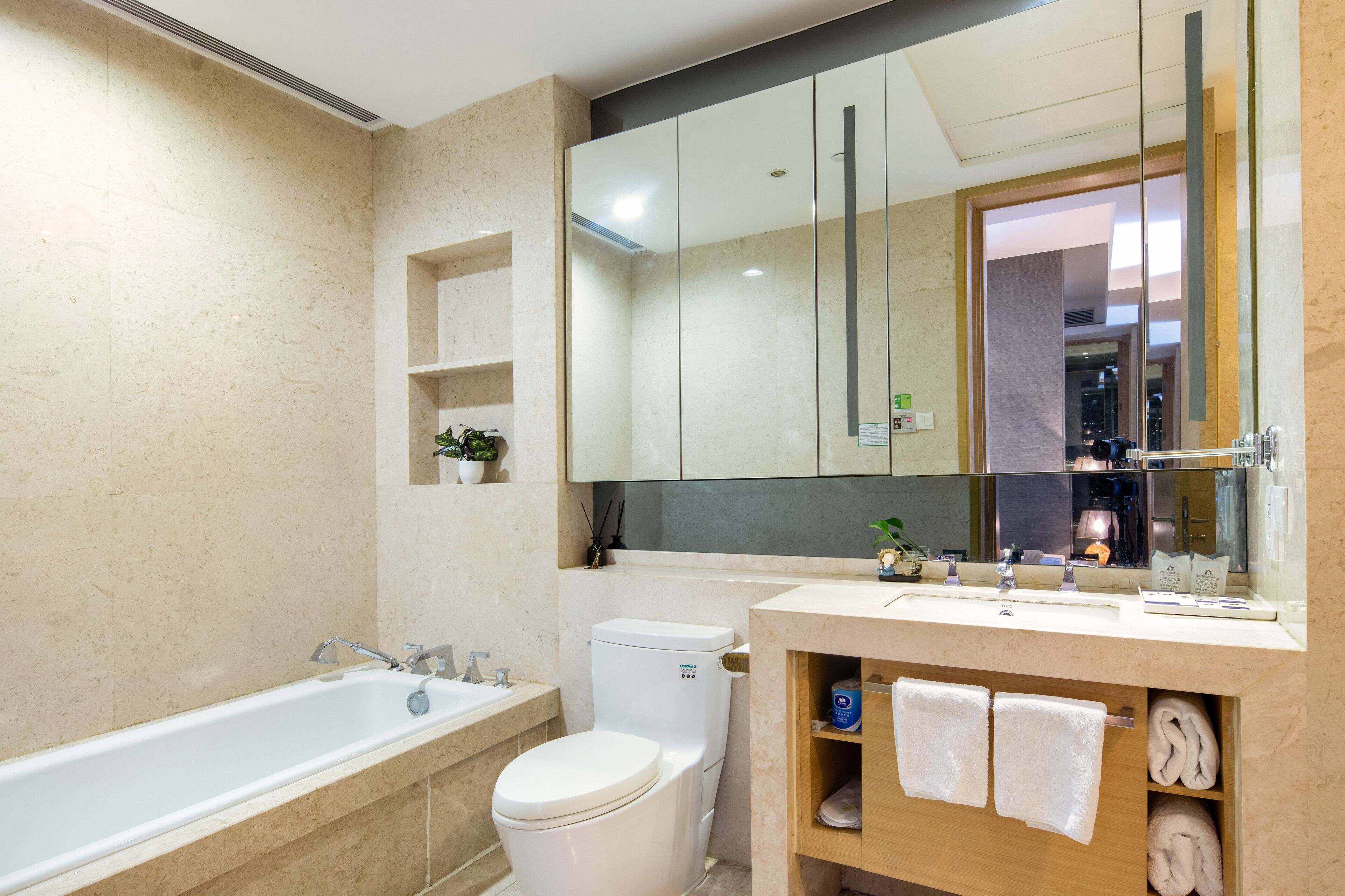 A modern bathroom with a bathtub, toilet, and vanity with a mirror.